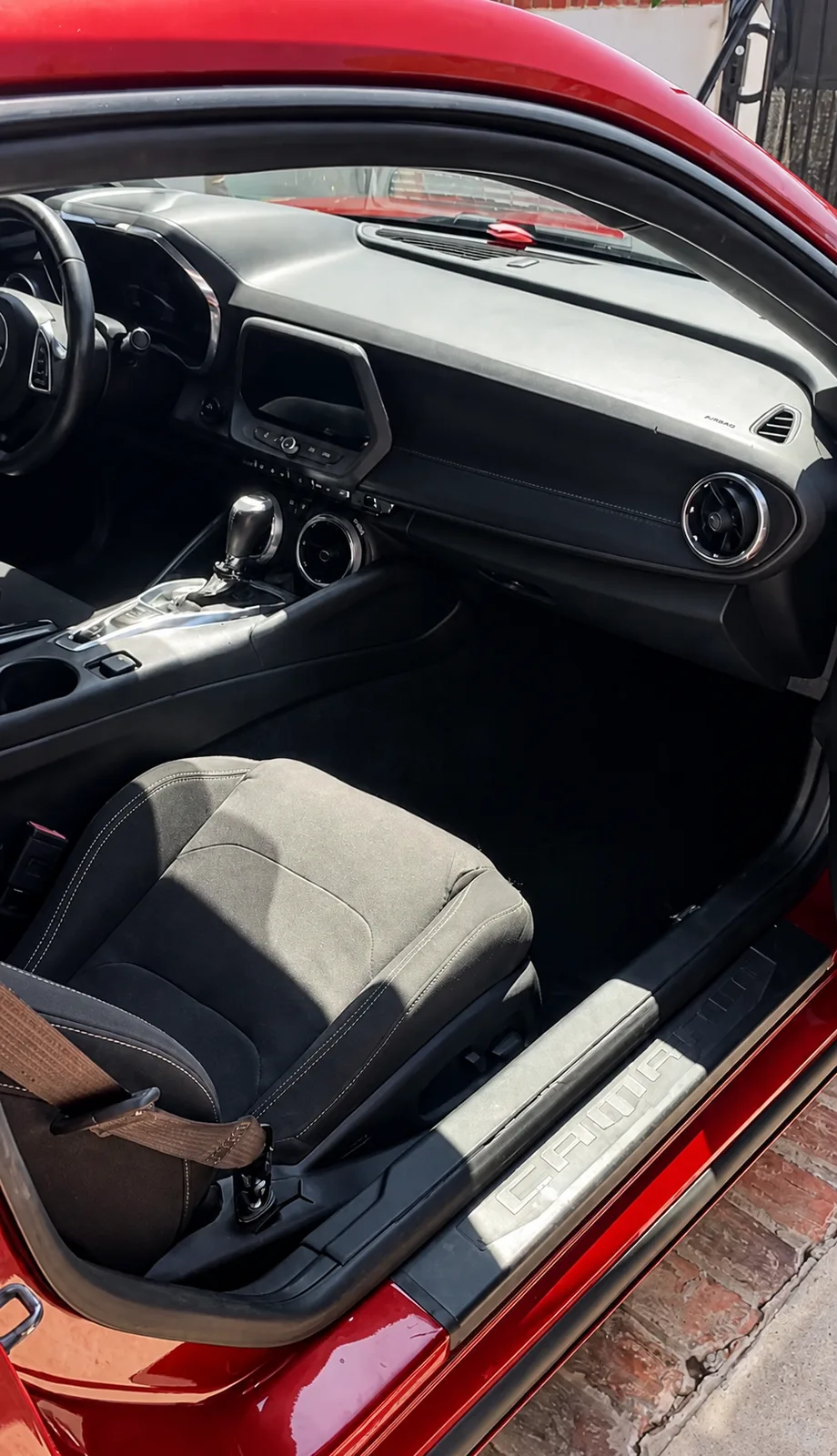 After — Chevrolet Camaro passenger footwell and seat — debris-strewn carpet and dusty dash, then vacuumed and conditioned