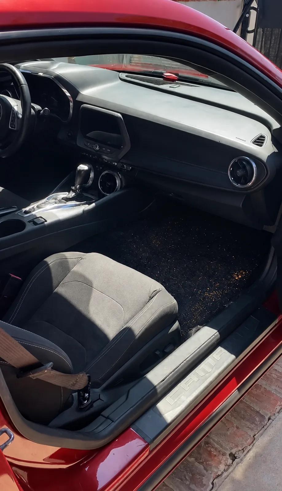 Before — Chevrolet Camaro passenger footwell and seat — debris-strewn carpet and dusty dash, then vacuumed and conditioned